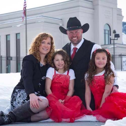 Travis Osmond family taking a group picture together.